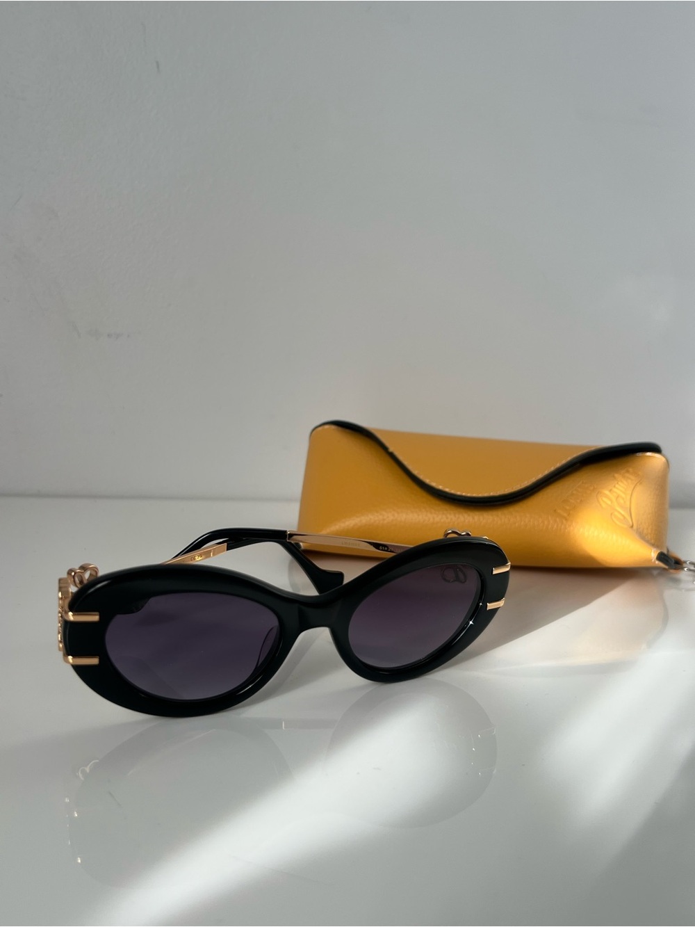 Loewe Black Oval Sunglasses with Gold Accents Anagram
